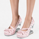 A pair of light pink satin Mary Jane heels with silver metallic spikes and small rhinestone embellishments, shown on a model's feet against a white background.