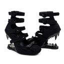 A pair of black high-heeled sandals with multiple straps, decorative bows, and sharp stiletto heels, shown on a plain white background with the text 'Dolly Bae' above them.