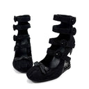 A pair of black lace-up wedge sandals with a fuzzy textured finish, displayed against a plain white background with the brand name 'Dolly Bae' printed in a gothic font above them.
