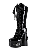 A glossy black patent leather knee-high boot with a chunky block heel, platform sole, side laces, and a silver chain detail on a white background.