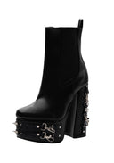 A black leather platform ankle boot with a high block heel, studded platform, and silver-tone decorative hardware on the side and heel.