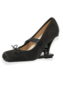 A single black Mary Jane style pump with a kitten heel and a small bow detail on the strap, shown against a plain white background.