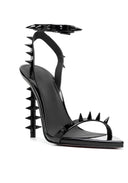 A single black patent leather stiletto sandal with a high studded heel, studded toe strap, and studded ankle strap, shown from a side profile on a white background.