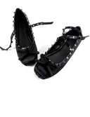 A pair of black satin ballet flats with silver rhinestone studded straps and bows, displayed on a white background with the brand name 'Dolly Bae' printed in a gothic font above.