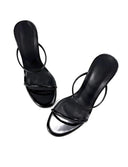 A pair of black strappy high-heeled sandals with a glossy finish, displayed on a clean white background with the brand name 'Dolly Bae' printed in a gothic font at the top.