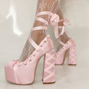 Pink platform high heels with lace-up design worn with fishnet stockings on a neutral background