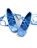 A pair of light blue satin ballet flats with matching ribbon laces, displayed on a white background with the text 'Dolly Bae' printed above.