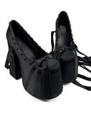 Black high-heeled shoes with decorative elements on a white background, featuring the brand 'Dolly Bae'.