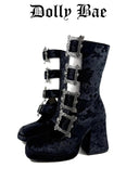 A pair of dark navy blue velvet ankle boots with gothic silver buckle embellishments, shown against a plain white background with the text 'Dolly Bae' printed above.