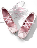 Pink ballet shoes with white ribbons on a white background, featuring the brand 'Dolly Bae'.