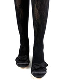 Black tights with bow details on a white background, featuring the brand 'Dolly Bae'.