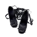A pair of black lace-up high heels with bow details and long dangling ribbon straps, shown on a plain white background with the text 'Dolly Bae' above them.