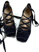 Black strappy shoes with 'Dolly Bae' branding on a white background