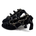 Black lace and satin gothic-style high heels with ruffled straps and gold-tone buckle details, shown on a white background with the text 'Dolly Bae' above.