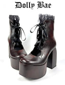 A pair of dark brown platform ankle boots with black lace-up fronts, sheer ruffled trim at the ankle, and chunky block heels, shown on a white background with the text 'Dolly Bae' above them.