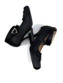 A pair of black Mary Jane-style high heels with a small silver buckle detail on the strap, shown from a top-down view on a white background with the text 'Dolly Bae' above them.