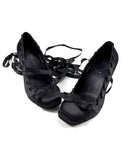 A pair of black lace-up flat shoes with decorative cutout details on the sides, displayed against a plain white background with the text 'Dolly Bae' printed above.