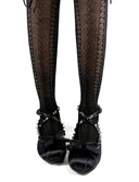 Black lace-up gothic shoes with rhinestone straps and bows, worn with patterned black tights, shown against a white background with the text 'Dolly Bae' below.