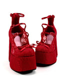 A pair of red platform Mary Jane-style heels with lace-up ankle straps and bow details, shown on a white background with the text 'Dolly Bae' above them.