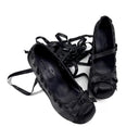 A pair of black leather gothic-style lace-up shoes with ribbon details, displayed on a white background with the brand name 'Dolly Bae' printed in a gothic font above them.