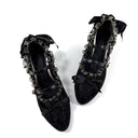 A pair of black gothic-style pointed-toe flats with lace, ruffles, and silver-tone studs, displayed on a white background with the brand name 'Dolly Bae' printed above.