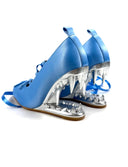 A pair of blue high-heeled shoes with metallic silver claw-like heels and blue straps, shown on a white background with the text 'Dolly Bae' above them.