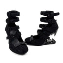 A pair of black strappy high-heeled shoes with a textured fabric upper and a spiked wedge heel, displayed against a plain white background with the brand name 'Dolly Bae' printed in a black gothic font above them.