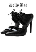 A pair of black studded high-heeled pumps with a crocodile-embossed texture, lace-up ankle straps, and silver-tone hardware, shown against a white background with the 'Dolly Bae' brand name printed in a gothic font at the top.